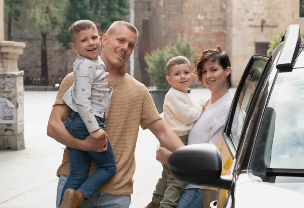 Familia con dos niños junto a un taxi.